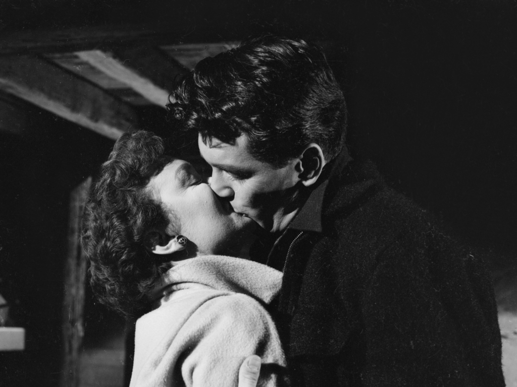 Still from ALL THAT HEAVEN ALLOWS. A couple kiss in a black and white image.