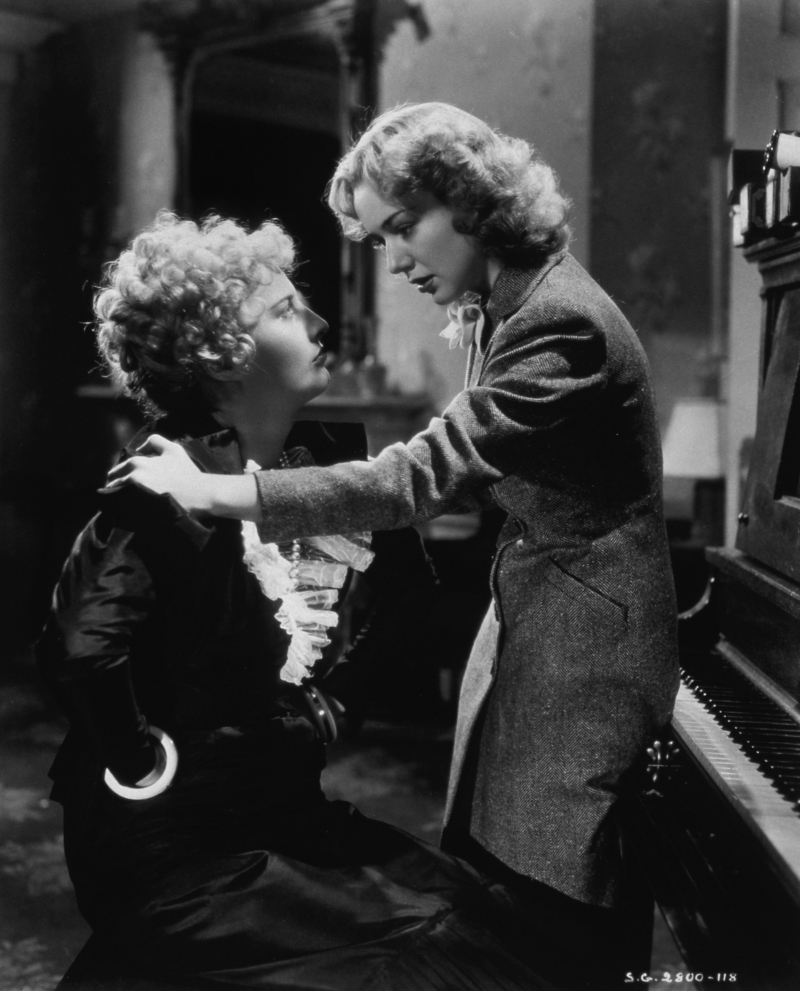 Still from STELLA DALLAS. A black and white image of two women sitting by a piano