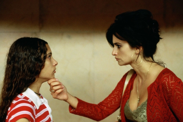 A still from Volver. Penelope Cruz looks at a teenage girl, holding her chin.