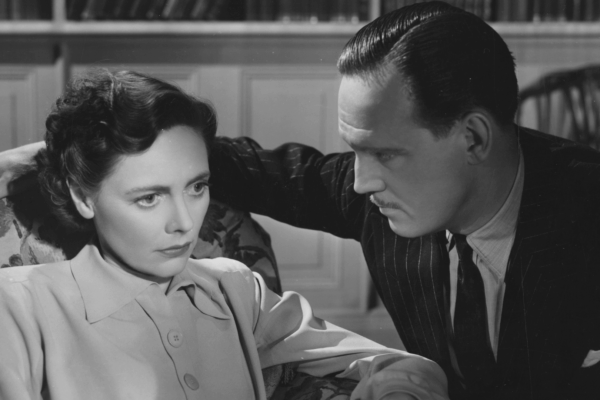 Still from Brief Encounter, a Too Much season title. A black and white image of a woman looking concerned and a man looking at her.