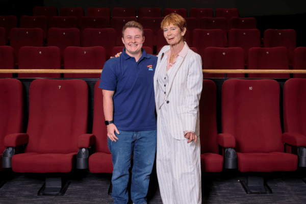 A staff member from Warwick Arts Centre and Celia Imrie pose for a photo in a cinema auditorium