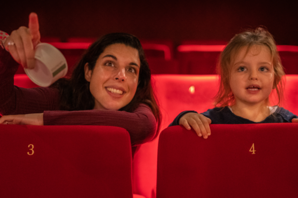 An adult and child sat in a cinema screen