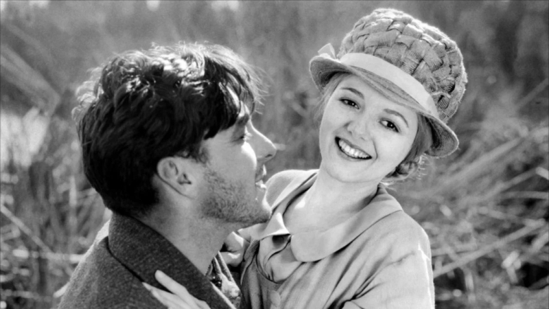 A still from Sunrise: A Song of Two Humans (1927). A man and woman embrace in the outdoors.